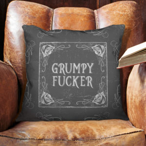 Front of grey colored "Grumpy Fucker" pillow from Insulting Pillows™ nestled on a beat up old chair. A perfect birthday gift.